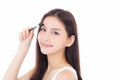 Beautiful portrait young asian woman applying eyebrow or eyelash with makeup brush isolated on white background Royalty Free Stock Photo