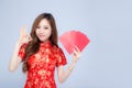 Beautiful portrait young asian woman cheongsam dress smiling holding red envelope and gesture ok on white background