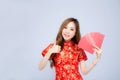 Beautiful portrait young asian woman cheongsam dress smiling holding red envelope and thumbs up on white background