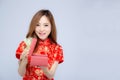 Beautiful portrait young asian woman cheongsam dress smiling holding red gift box on white background