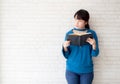 Beautiful of portrait young asian woman happiness relax standing reading book on concrete cement white background Royalty Free Stock Photo