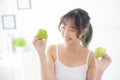 Beautiful portrait young asian woman holding and eating green apple fruit in the bedroom at home Royalty Free Stock Photo