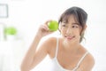 Beautiful portrait young asian woman holding and eating green apple fruit in the bedroom at home Royalty Free Stock Photo