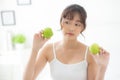 Beautiful portrait young asian woman holding and eating green apple fruit in the bedroom at home Royalty Free Stock Photo