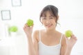 Beautiful portrait young asian woman holding and eating green apple fruit in the bedroom at home Royalty Free Stock Photo