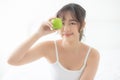 Beautiful portrait young asian woman holding and eating green apple fruit in the bedroom at home Royalty Free Stock Photo