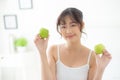Beautiful portrait young asian woman holding and eating green apple fruit in the bedroom at home. Royalty Free Stock Photo