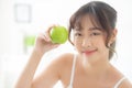 Beautiful portrait young asian woman holding and eating green apple fruit in the bedroom at home.. Royalty Free Stock Photo