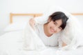 Beautiful portrait young asian woman lying and smile while wake up with sunrise at morning, girl with happy annd fun Royalty Free Stock Photo