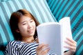 Beautiful of portrait young asian woman relax lying reading book on sofa in bedroom at home Royalty Free Stock Photo