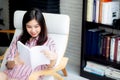 Beautiful of portrait young asian woman relax sitting reading book in living room Royalty Free Stock Photo