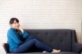 Beautiful portrait young asian woman sitting and smiling happy and looking at camera on sofa with casual at living room Royalty Free Stock Photo