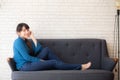 Beautiful portrait young asian woman sitting and smiling happy and looking at camera on sofa with casual at living room Royalty Free Stock Photo