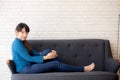 Beautiful portrait young asian woman sitting and smiling happy and looking at camera on sofa with casual at living room Royalty Free Stock Photo