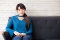 Beautiful portrait young asian woman sitting and smiling happy and looking at camera on sofa with casual at living room Royalty Free Stock Photo