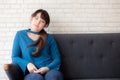 Beautiful portrait young asian woman sitting and smiling happy and looking at camera on sofa with casual at living room Royalty Free Stock Photo