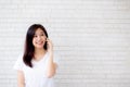 Beautiful of portrait young asian woman talk smart phone and smile standing on cement brick background Royalty Free Stock Photo