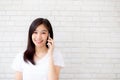 Beautiful of portrait young asian woman talk smart phone and smile standing on cement brick background Royalty Free Stock Photo