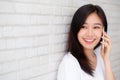 Beautiful of portrait young asian woman talk smart phone and smile standing on cement brick background Royalty Free Stock Photo