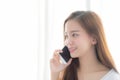 Beautiful of portrait young asian woman talking smart mobile phone and smile standing at curtain background on bedroom Royalty Free Stock Photo