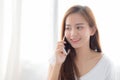 Beautiful of portrait young asian woman talking smart mobile phone and smile standing at curtain background on bedroom Royalty Free Stock Photo