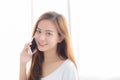 Beautiful of portrait young asian woman talking smart mobile phone and smile standing at curtain background on bedroom Royalty Free Stock Photo