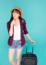 Beautiful portrait young asian woman thinking idea travel in vacation with luggage isolated on blue background Royalty Free Stock Photo