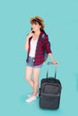 Beautiful portrait young asian woman thinking idea travel in vacation with luggage isolated on blue background. Royalty Free Stock Photo