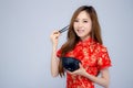 Beautiful portrait young asian woman wear red cheongsam holding chopsticks and bowl isolated Royalty Free Stock Photo