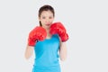 Beautiful portrait young asian woman wearing red boxing gloves with strength and strength isolated on white background Royalty Free Stock Photo