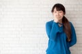 Beautiful portrait young asian woman yawning and sleepy on grey cement texture grunge wall brick background