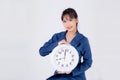 Beautiful portrait young business asian woman smiling holding clock isolated on white background Royalty Free Stock Photo