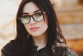 Beautiful positive fashionable stylish modern brunette girl in trendy glasses looking at camera Royalty Free Stock Photo