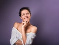 Beautiful positive young casual woman with hand under the face thinking and looking up in white shirt on purple background Royalty Free Stock Photo