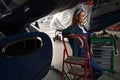 Beautiful positive woman relief engineer in uniform working in aviation garage Royalty Free Stock Photo