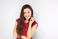 Beautiful positive young happy woman with hand under the face thinking and looking in casual red shirt and long hair on blue Royalty Free Stock Photo