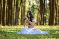 beautiful potrait asian woman siting and listening to headphone music in a pine forest and holding retro camera with rose flowers