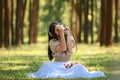 beautiful potrait asian woman siting and listening to headphone music in a pine forest and holding retro camera with rose flowers
