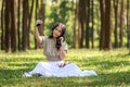 beautiful potrait asian woman siting and listening to headphone music in a pine forest and holding selfie with mobile phone, retro