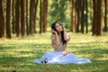 beautiful potrait asian woman siting and listening to headphone music in a pine forest and retro camera with rose flowers in frame
