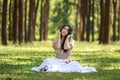 beautiful potrait asian woman siting and listening to headphone music in a pine forest and retro camera with rose flowers in frame