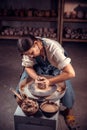 Charming pottery woman making ceramic pot on the pottery wheel . Pottery workshop.
