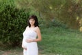 Beautiful pregnancy woman in park, garden. Outdoor