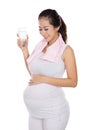 Beautiful pregnant asian woman holding a glass of water, smiling Royalty Free Stock Photo