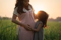 Beautiful pregnant asian woman with daughter playing on her tummy Royalty Free Stock Photo