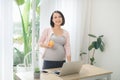 Beautiful pregnant businesswoman eating apple and smiling at camera Royalty Free Stock Photo