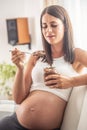 Beautiful pregnant female craving peanut butter holds a spoon full of peantut butter and a jar Royalty Free Stock Photo