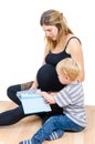 Beautiful pregnant happy mother with child boy reading book isolated Royalty Free Stock Photo