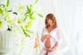 Beautiful pregnant in light white dress with orchids Royalty Free Stock Photo