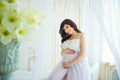 Beautiful pregnant in light white dress with orchids Royalty Free Stock Photo